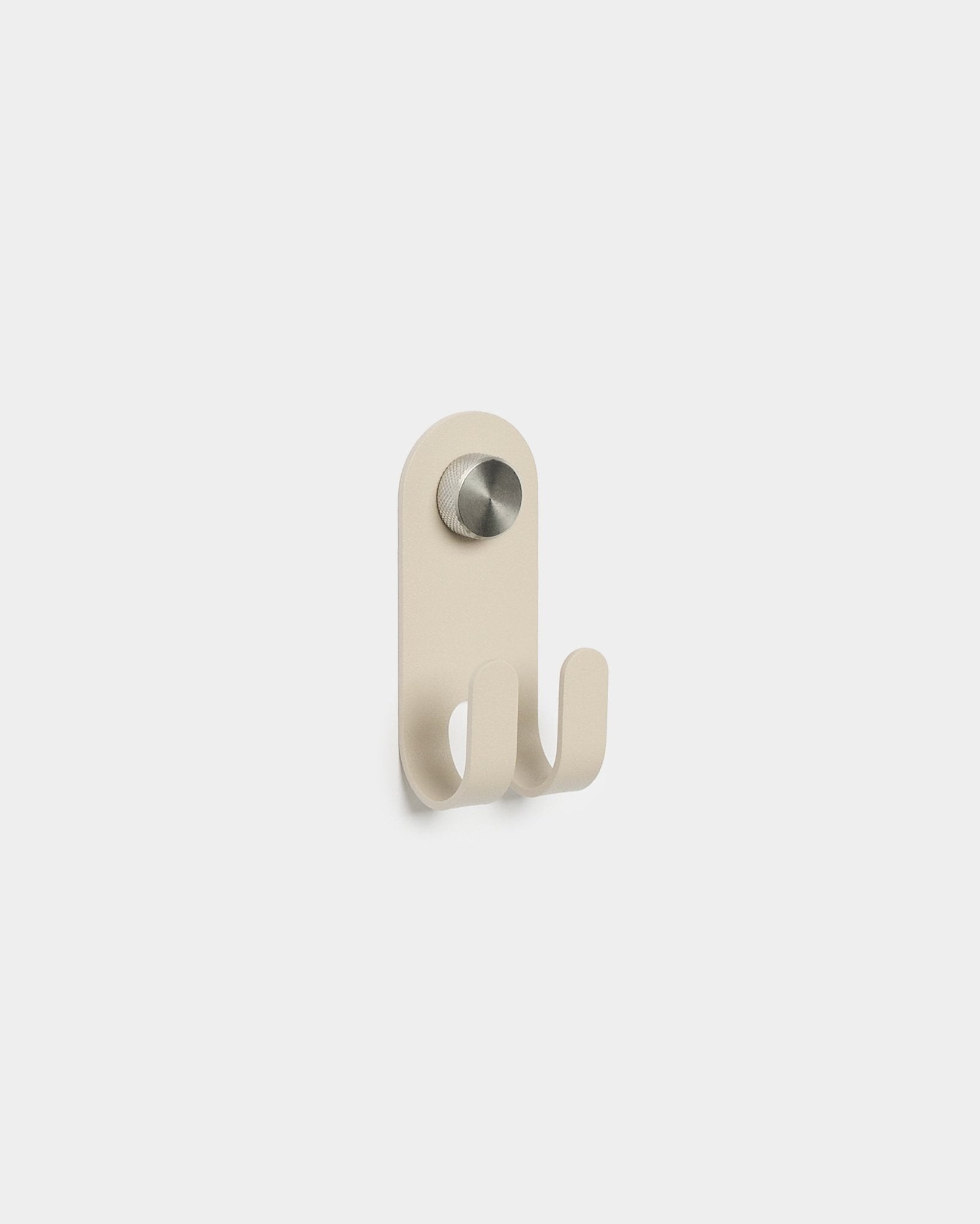 WoodUpp Norr Double Hanger in beige con due ganci in metallo e un pomello circolare argentato, design nordico minimalista, su uno sfondo bianco semplice.